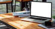 © NAMPIX - Mockup blank screen laptop computer on wooden table, creative workspace.