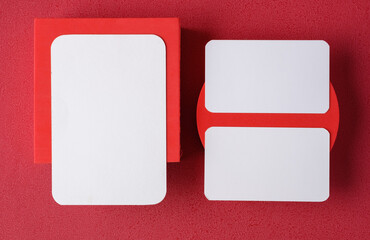 Poster - blank business card on pedestal on vivid red background studio