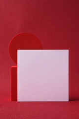 Poster - blank business card on pedestal on vivid red background studio