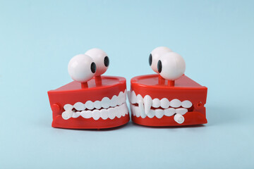 Funny toys clockwork jumping teeth with eyes on blue background