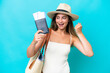 © luismolinero - Young woman in swimsuit holding passport isolated on blue background celebrating a victory
