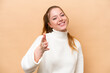 © luismolinero - Young caucasian woman isolated on beige background shaking hands for closing a good deal