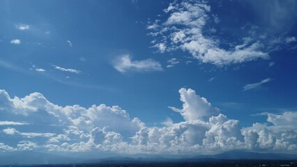 Wall Mural - Aerial view of the blue sky with white clouds in summer day. Time lapse of white clouds and sunny blue skies. Natural background in motion. drone shooting clouds motion time