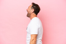 Middle Age Volunteer Man Isolated On Pink Background Isolated On Pink Background Laughing In Lateral Position