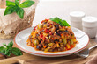 Caponata siciliana - italian, sicilain stew consisting of chopped fried aubergine oe eggplant and other  vegetables like celery, omion, olives, bell pepper, tomato and toasted pine nuts.