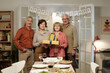 © pressmaster - Group of four happy senior friends with packed giftboxes looking at camera while enjoying birthday party of one of them