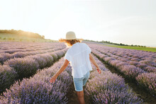 Woman Touching Lavender Flowers Walking In Field