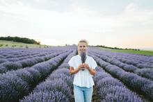 Smiling Woman With Bouquet Of Lavender Flowers Standing In Field