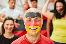 Happy Man With German Flag Painted On Face At Stadium