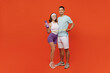 Full body side view young fitness trainer instructor sporty two man woman in headband t-shirt hold measure tape bottle spend weekend in gym isolated on plain orange background. Workout sport concept.