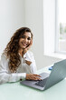 © dianagrytsku - Young beautiful joyful woman smiling while working with laptop in office