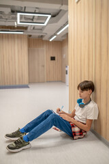 Wall Mural - A boy sitting on the floor and doing his homework