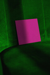 Mockup of pink blank square certificate cards on green soft chair background, minimal, fashion, space, vertical