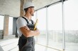 © Serhii - Man builder working in construction site. Male repairer in overall and helmet.