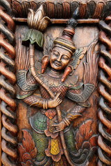 Wall Mural - Wooden sculpture : apsara holding a lotus flower.