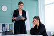 © Andrii - Young women leaders are checking financial statements from paper documents. Two female confident business worker dressed black suit in office checking financial document
