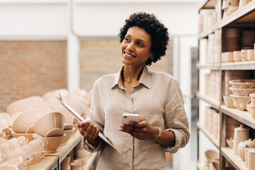 Happy female ceramist contemplating new creative ideas for her store