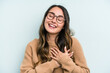 © Asier - Young caucasian woman isolated on blue background has friendly expression, pressing palm to chest. Love concept.