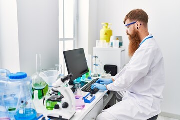 Poster - Young redhead man wearing scientist uniform working at laboratory