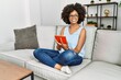 © Krakenimages.com - Young african american woman smiling confident using touchpad at home
