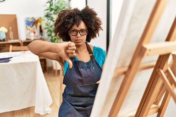 Sticker - Beautiful african american woman with afro hair painting canvas at art studio with angry face, negative sign showing dislike with thumbs down, rejection concept