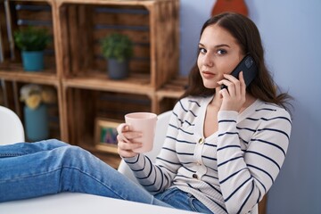 Poster - Young woman talking on smartphone drinking coffee at home