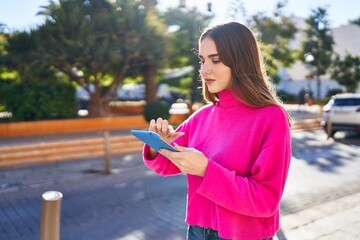 Young woman using touchpad at street