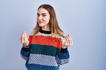 Sticker - Young hispanic girl standing over blue background doing money gesture with hands, asking for salary payment, millionaire business