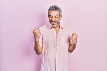 Poster - Handsome middle age man with grey hair wearing casual shirt excited for success with arms raised and eyes closed celebrating victory smiling. winner concept.