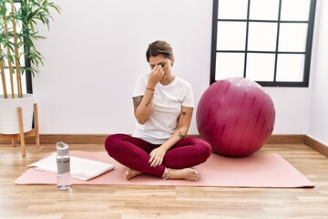 Sticker - Young hispanic woman training at sport center tired rubbing nose and eyes feeling fatigue and headache. stress and frustration concept.