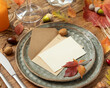 Autumn table setting with place card and envelope between leaves and berries close up, mockup