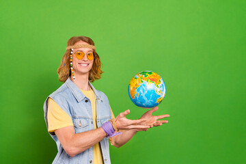 Sticker - Portrait of attractive cheerful hippie guy throwing globe agency season isolated over bright green color background