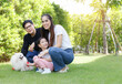 © atitaph - Asian family is happy, bright, cute, daughter is relaxing, playing with the dog in the grass