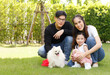 © atitaph - Asian family is happy, bright, cute, daughter is relaxing, playing with the dog in the grass