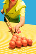 © master1305 - Creative image of female hands playing billiards, hitting egg balls with cue isolated on blue yellow background