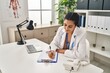 © Krakenimages.com - Young hispanic woman wearing doctor uniform writing medical report at clinic