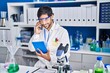 © Krakenimages.com - Young hispanic man scientist talking on the smartphone using touchpad at laboratory