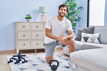 Sticker - Young hispanic man sporty using stopwatch at home