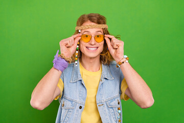 Sticker - Portrait of attractive cheerful hippie guy touching specs good mood isolated over bright green color background