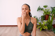 A young woman meditates with alternate nostril breathing to calm anxiety