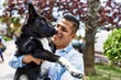 © Krakenimages.com - Young latin man smiling happy holding dog at the city.