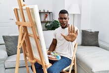 Young African Man Painting On Canvas At Home Doing Stop Gesture With Hands Palms, Angry And Frustration Expression