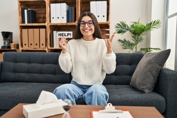 Poster - Young hispanic woman going to therapy at consultation office asking for help celebrating victory with happy smile and winner expression with raised hands