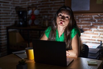 Sticker - Young teenager girl working at the office at night making fish face with lips, crazy and comical gesture. funny expression.