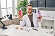 © Krakenimages.com - Middle age caucasian dentist man holding mouthwash for fresh breath winking looking at the camera with sexy expression, cheerful and happy face.