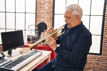 Wall Mural - Senior man musician playing trumpet at music studio