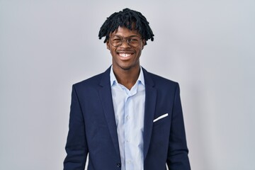 Sticker - Young african man with dreadlocks wearing business jacket over white background winking looking at the camera with sexy expression, cheerful and happy face.