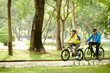 © DragonImages - Couple enjoying bicycle ride in city park on sunny Sunday morning