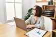 © Krakenimages.com - Brunette woman with down syndrome working using laptop at business office