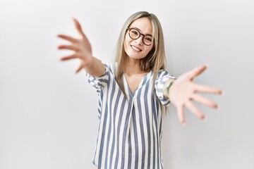 Sticker - Asian young woman wearing casual clothes and glasses looking at the camera smiling with open arms for hug. cheerful expression embracing happiness.